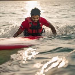 Man getting back on a paddleboard after falling off