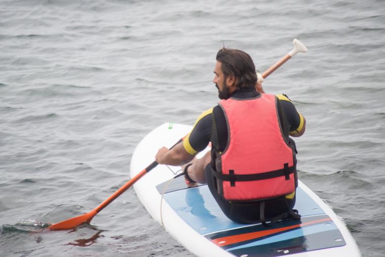 SUP for non-swimmers paddleboarder sitting with life vest