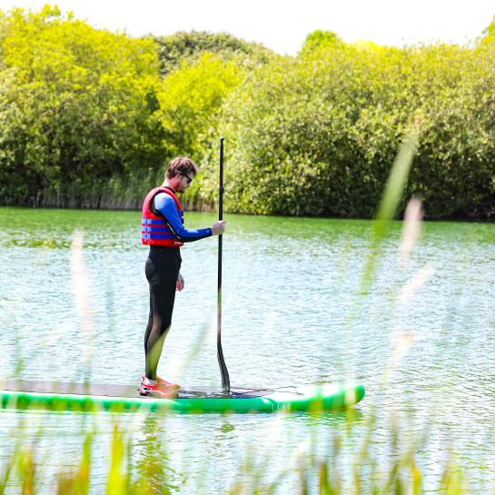 SUP for non-swimmers paddleboarder standing with life vest