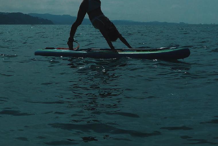 woman doing yoga on a paddleboard