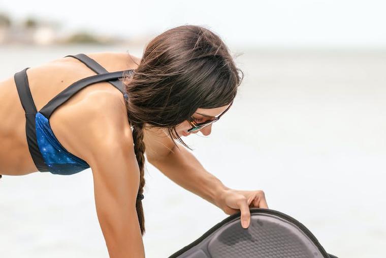 Woman setting up a SUP seat onto a paddleboard