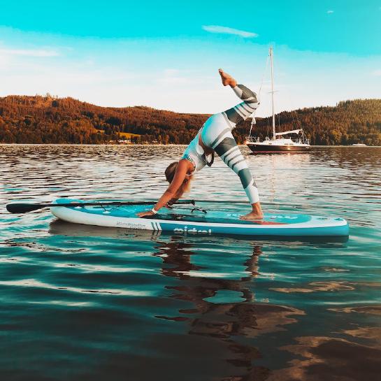 Woman doing yoga on a paddleboard on the water