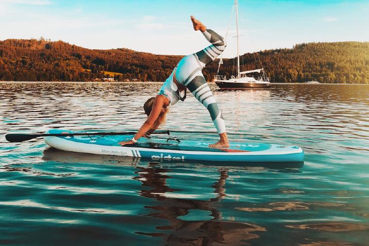 Woman doing yoga on a paddleboard on the water