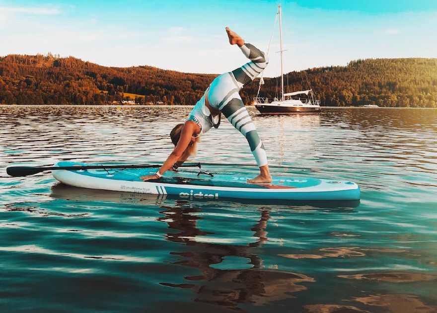 Woman doing yoga on a paddleboard on the water