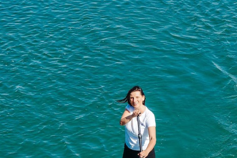 Woman paddling on a SUP looking at the camera